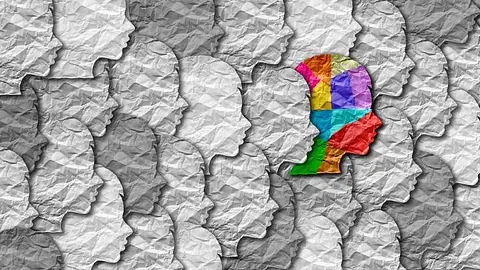 Farget papirprofil skiller seg ut blant grå silhuetter.